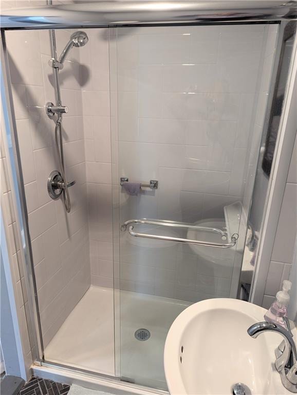 full bath with a stall shower and a sink