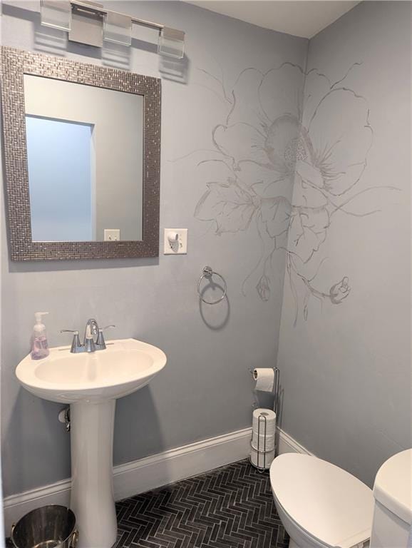 bathroom featuring toilet and baseboards