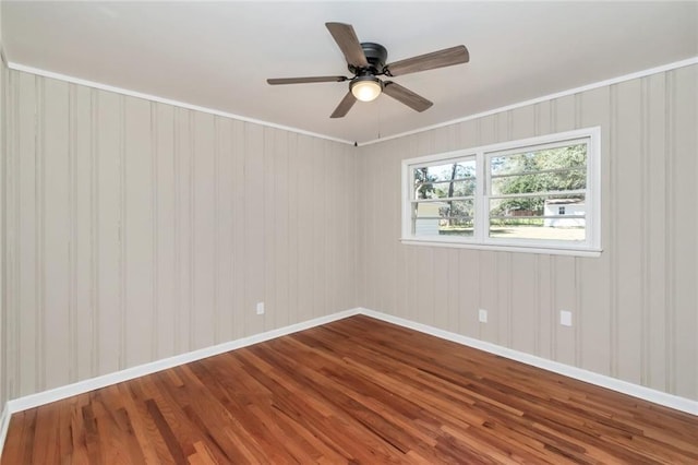 spare room with a ceiling fan, baseboards, and wood finished floors