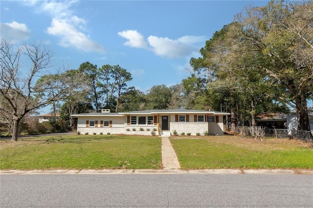 ranch-style home with fence and a front lawn