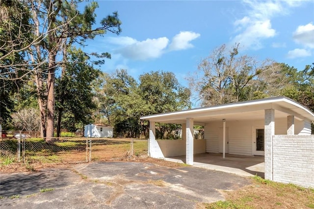 view of vehicle parking with driveway and fence