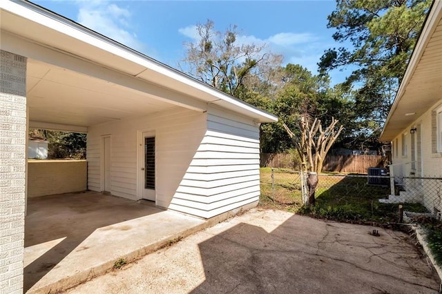 exterior space featuring an attached carport and fence