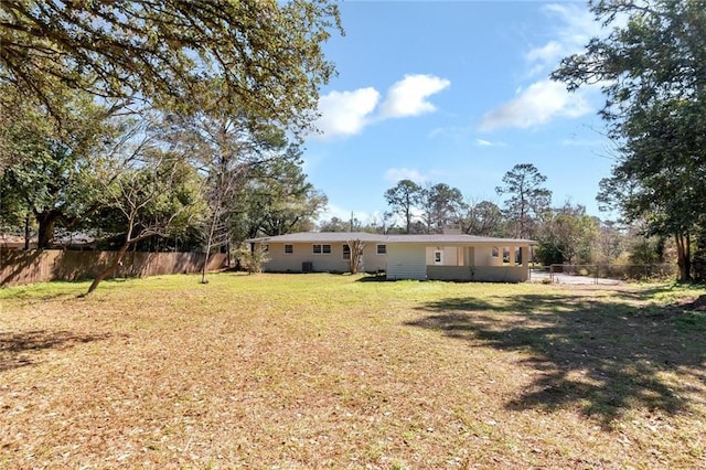 back of property with a fenced backyard and a yard