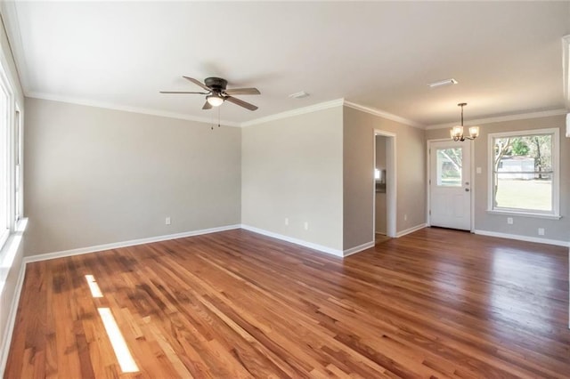 interior space featuring ceiling fan with notable chandelier, dark wood-type flooring, ornamental molding, and baseboards