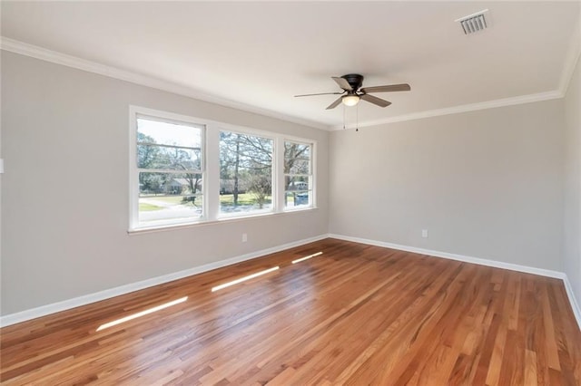 unfurnished room with light wood-type flooring, visible vents, baseboards, and ornamental molding