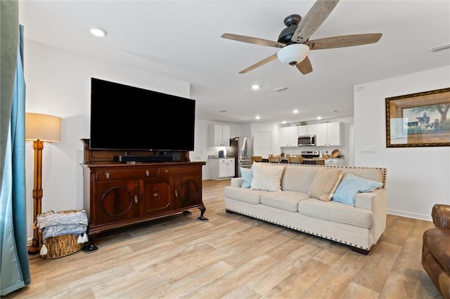 living room with ceiling fan and light hardwood / wood-style flooring