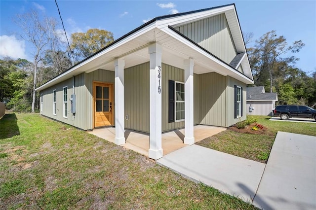 view of property exterior with a yard and covered porch