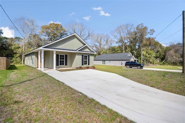 view of front facade featuring concrete driveway, fence, and a front yard