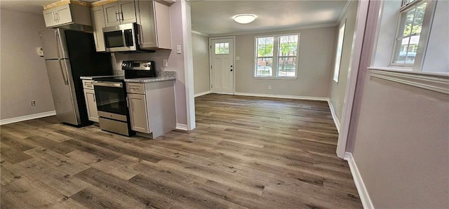 kitchen featuring light stone countertops, hardwood / wood-style floors, stainless steel appliances, and crown molding