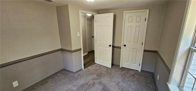 unfurnished bedroom featuring dark colored carpet