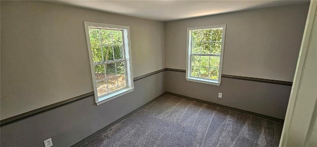 unfurnished room with dark carpet