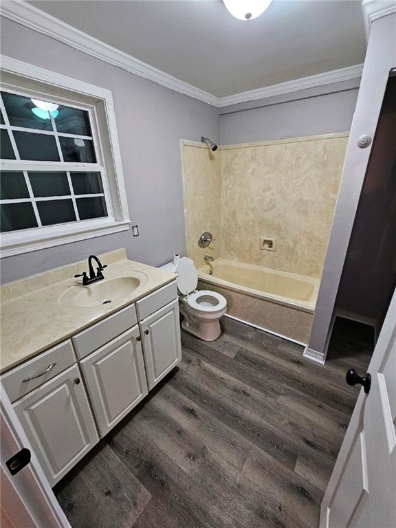 full bathroom with shower / tub combination, crown molding, vanity, hardwood / wood-style flooring, and toilet