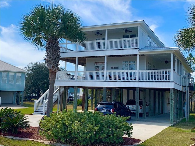 exterior space featuring a ceiling fan, stairway, a carport, and concrete driveway