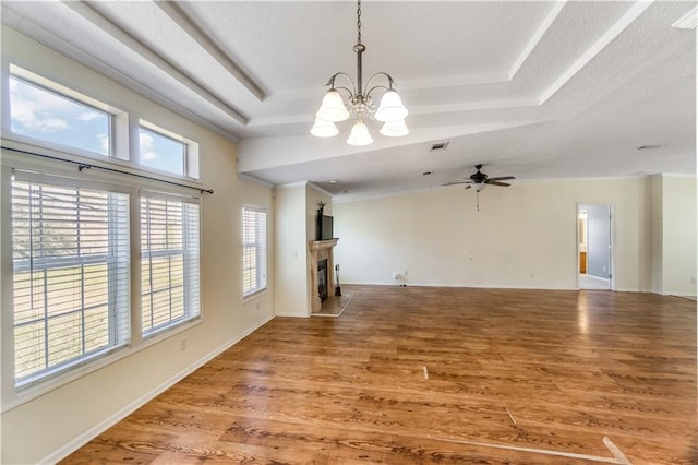 unfurnished living room with light wood finished floors, a fireplace, baseboards, and a raised ceiling