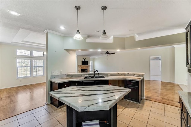 kitchen with open floor plan, light countertops, light tile patterned flooring, and a kitchen island