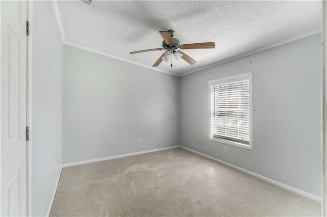 empty room with baseboards, a ceiling fan, a textured ceiling, crown molding, and carpet flooring