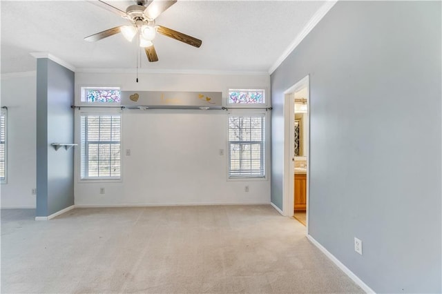 spare room with baseboards, light colored carpet, and crown molding