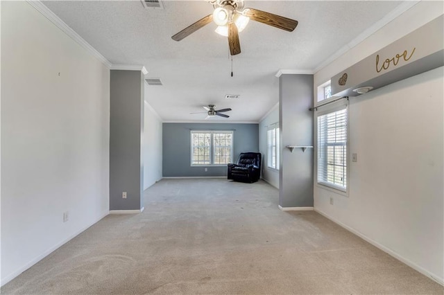 unfurnished living room with a healthy amount of sunlight, carpet, visible vents, and ornamental molding