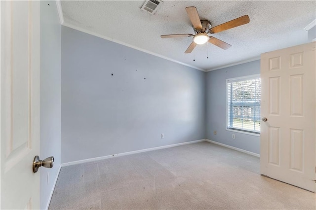 carpeted spare room with baseboards, a textured ceiling, visible vents, and crown molding