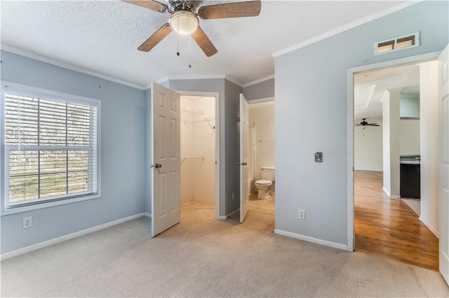 unfurnished bedroom with a textured ceiling, light colored carpet, visible vents, baseboards, and crown molding