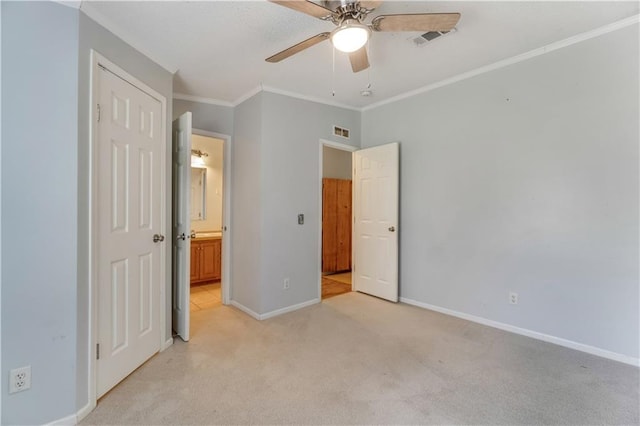 unfurnished bedroom with light colored carpet, crown molding, visible vents, and baseboards