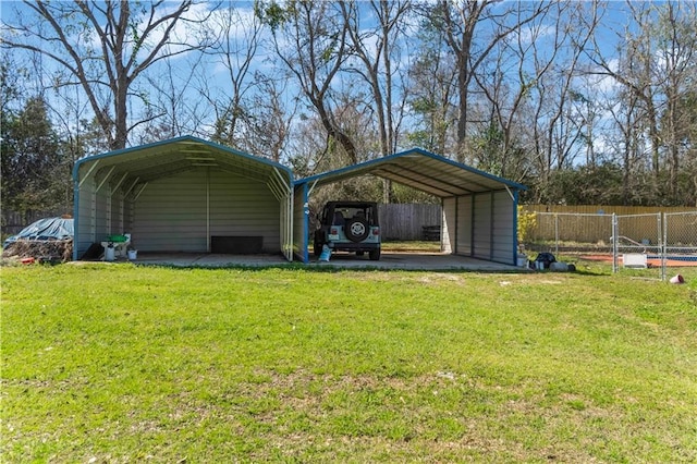 view of outbuilding with fence and a detached carport