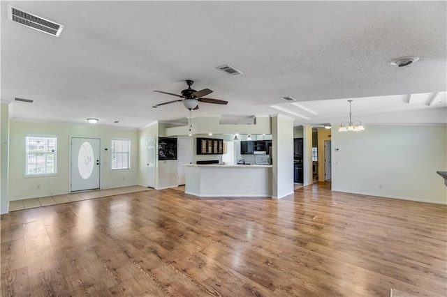 unfurnished living room with light wood-style floors, visible vents, and ceiling fan with notable chandelier