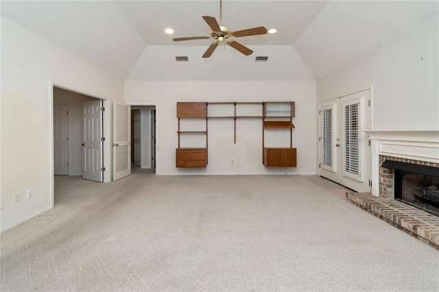 unfurnished living room with ceiling fan, a fireplace, high vaulted ceiling, and light carpet