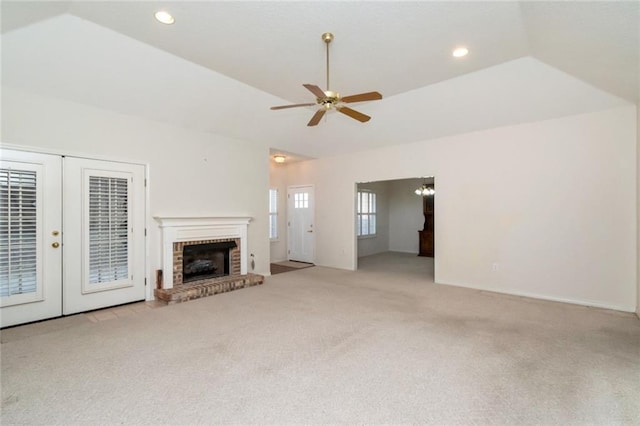 unfurnished living room featuring french doors, vaulted ceiling, a brick fireplace, light carpet, and ceiling fan