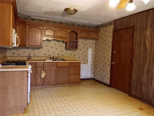 609 Gehrig Ave, Prichard, AL 36610 - kitchen with white appliances, wallpapered walls, light countertops, light floors, and brown cabinets