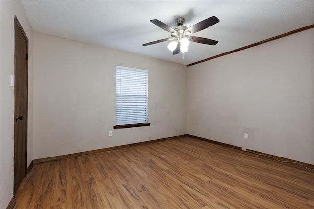 unfurnished room with ceiling fan, wood-type flooring, and crown molding