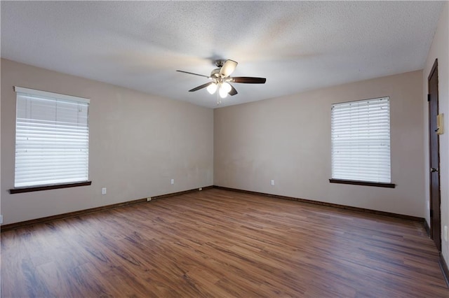 spare room featuring dark wood-type flooring, a textured ceiling, and ceiling fan