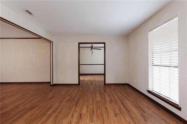 empty room with visible vents, baseboards, and wood finished floors