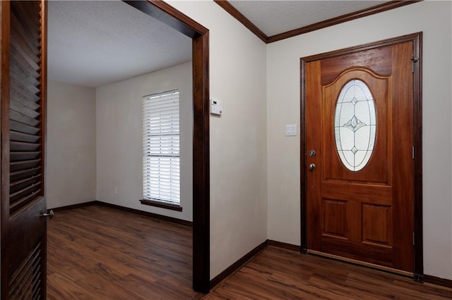 foyer entrance with ornamental molding, dark wood-type flooring, a textured ceiling, and baseboards