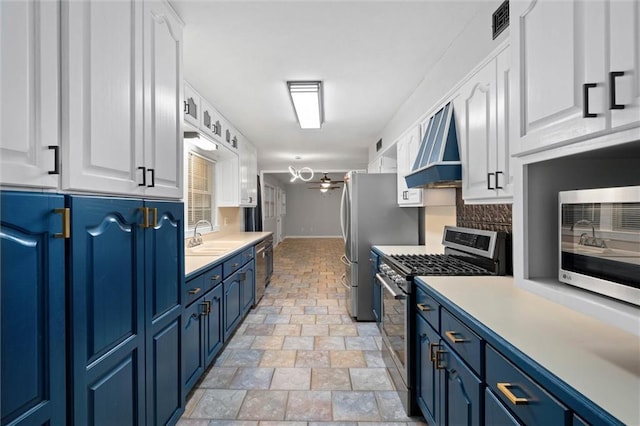 409 Byron Ave E, Mobile, AL 36609 - kitchen featuring stainless steel appliances, blue cabinets, custom exhaust hood, and white cabinets