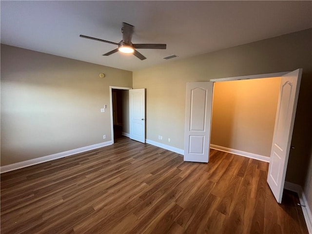 unfurnished bedroom with dark wood-type flooring and ceiling fan