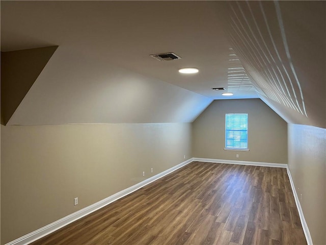 additional living space with lofted ceiling and dark wood-type flooring