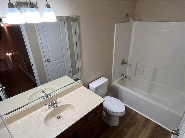 full bathroom featuring wood-type flooring, vanity, shower / washtub combination, and toilet