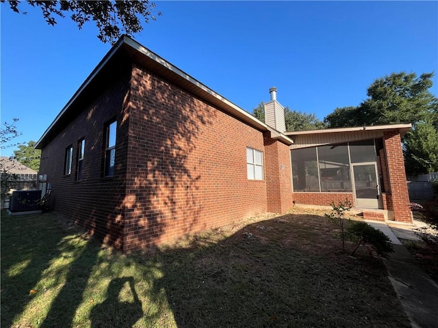 view of property exterior with a yard and a sunroom