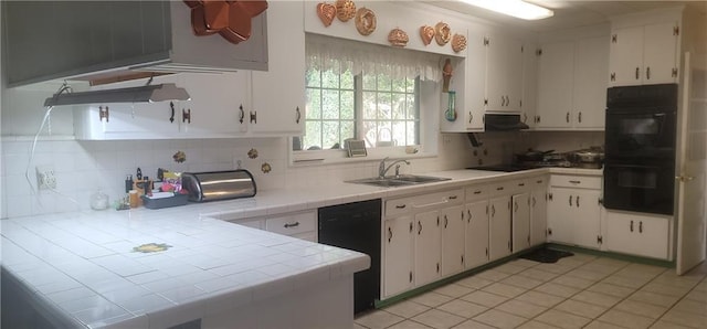 kitchen with backsplash, tile countertops, white cabinetry, and black appliances