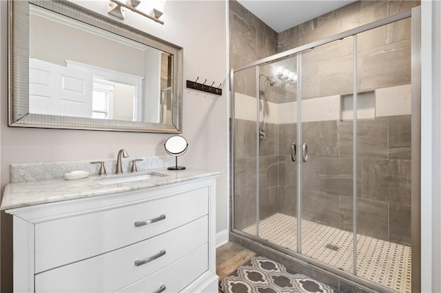 bathroom with hardwood / wood-style flooring, vanity, and a shower with shower door