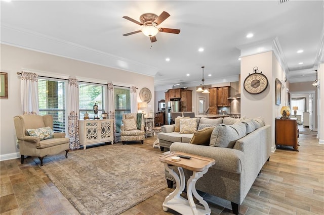 living room featuring ceiling fan, light wood-type flooring, and ornamental molding