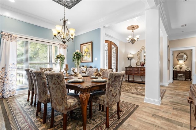 dining space featuring light wood-type flooring, a chandelier, and crown molding