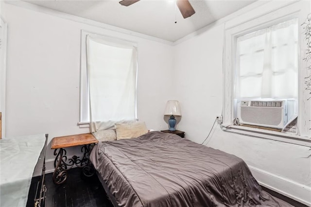 bedroom with cooling unit, hardwood / wood-style flooring, and ceiling fan