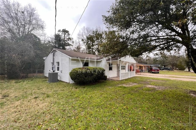 view of home's exterior with a lawn, a carport, and central AC