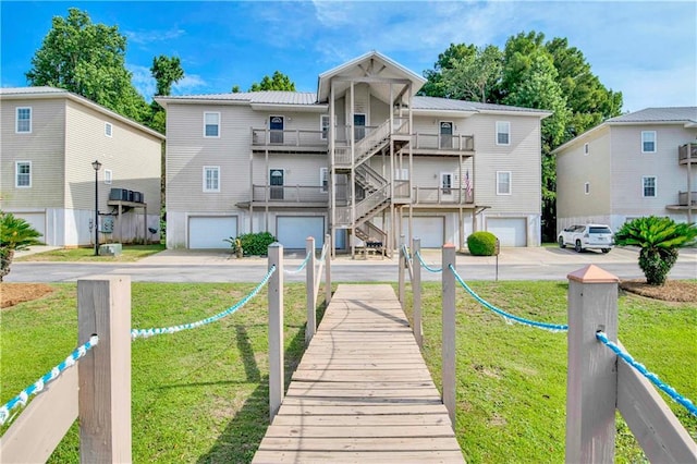 rear view of house with a balcony and a lawn