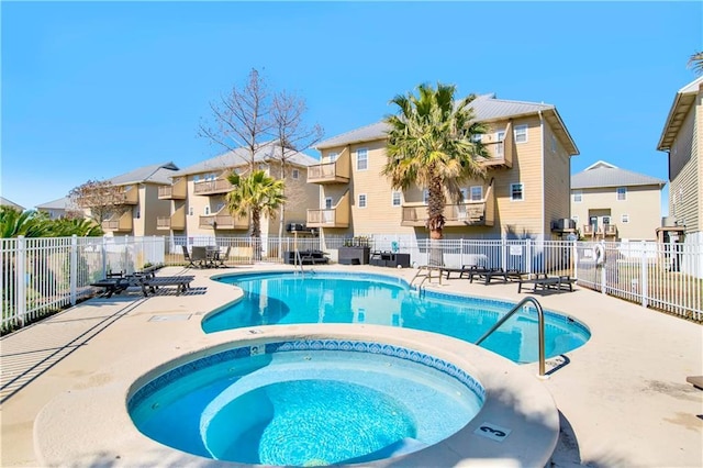 view of swimming pool featuring a hot tub and a patio area