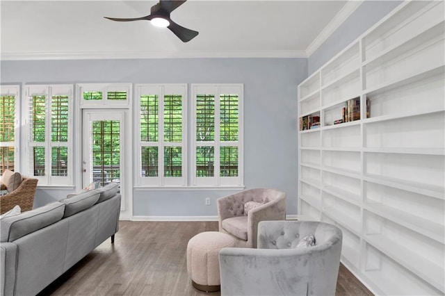 interior space featuring dark wood-type flooring, plenty of natural light, ceiling fan, and ornamental molding