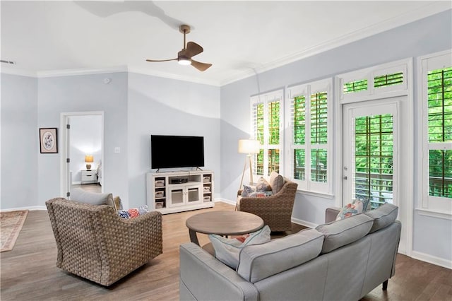 living room featuring ceiling fan, wood-type flooring, plenty of natural light, and ornamental molding