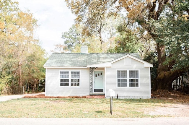 view of front of property featuring a chimney and a front yard